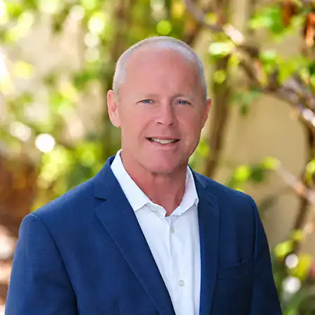 Chris Diamond - Right Path Recovery San Diego - Right Path Recovery San Diego Professional headshot of a smiling man in a blue suit outdoors with greenery in the background.